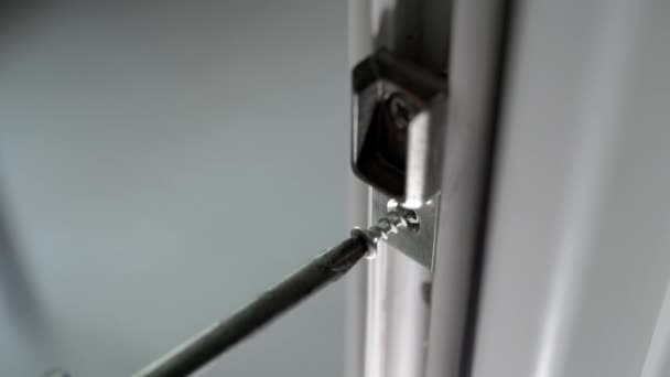用螺丝刀和自攻螺钉拧塑料门的连接件 安装后的白色塑料门的组装和调整 高质量的4K镜头 — 图库视频影像