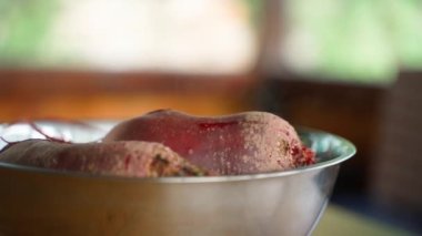 Freshly boiled red beets cool down outdoors close-up. Soaring boiled vegetables on a blurred background. Smooth camera movement. High quality FullHD footage
