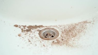 White ceramic washbasin dirty and dusty. The drain hole of the sink is covered with earth close-up. Smooth camera movement. High quality FullHD footage
