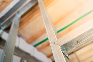 Frame from a metal profile for drywall close-up on a blurred background. Connection of parts from a metal profile in an interior partition