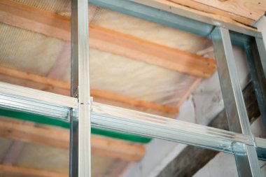 Frame from a metal profile for drywall close-up on a blurred background. Connection of parts from a metal profile in an interior partition