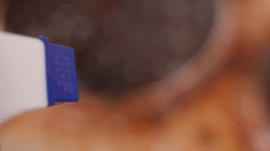 A very dirty surface is sprayed from a spray bottle close-up. A dirty kitchen electric stove on a blurred background is poured with detergent. High quality 4k footage