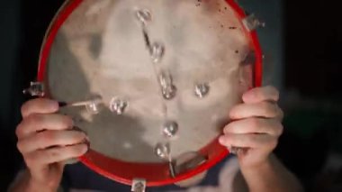 Hands shaking a tambourine with bells close-up. High quality 4k footage