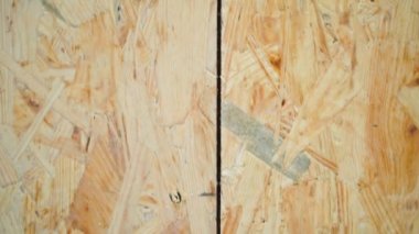 Close-up of uniform gap between oriented strand boards. The gap is designed for the expansion and contraction of wood in the osb slab. Screwed with black self-tapping screws, a draft plywood floor