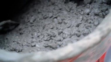 A concrete mixer mixes cement mortar with small gravel close-up in slow motion. Preparation of mortar for pouring concrete foundation. industrial background. High quality FullHD footage