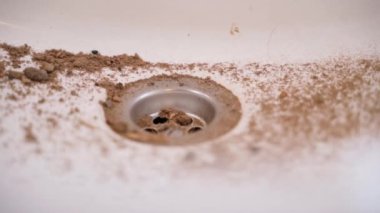 Lavabo kumda, yakın plan kumda. Banyoda inşaat tozu, pürüzsüz parallaks. Yüksek kaliteli FullHD görüntüler