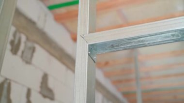 Close-up of a metal profile frame for drywall. Connection of two metal profiles with self-tapping screws. Smooth camera movement. High quality FullHD footage