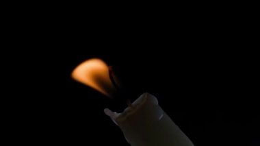 Candle burning close-up on a black background with a littered horizon. High quality 4k footage