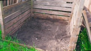 Humus seçiminden sonra tahta gübre kutusu boşaldı. Sebze bahçesinin yanında organik ve yiyecek atıkları için uygun bir yer, düzgün kamera hareketi. Yüksek kaliteli FullHD görüntüler