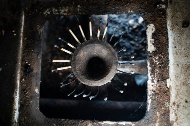 Yakından çekilen bir gaz sobasının ocağında yanan kibrit yerine, yanmış ahşap kibrit. Düşük yaşam standardı, kötü koşullarda hayatta kalma. Doğal gaz tasarrufu. Gecekondu mahallelerine giden mavi yakıtı kesiyorum.