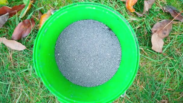バケツのクローズアップで灰色の粒状の土壌肥料 秋に木の土壌を供給するための過リン酸塩 高品質のフルHd映像 — ストック動画