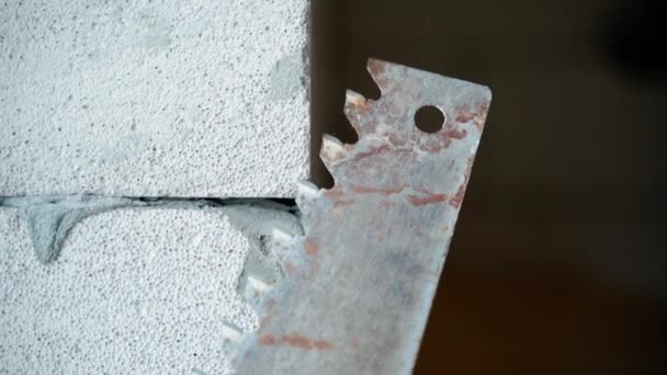 在充气混凝土砖墙的背景下 一个用于充气混凝土特写的旧手工锯子 锯子和气体块 优质Fullhd影片 — 图库视频影像