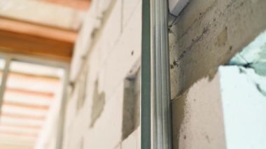 Havalandırmalı beton bir duvara metal bir profil tutturmak. Yüksek kaliteli FullHD görüntüler