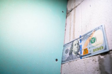 Neme dayanıklı alçıpan yakınında havalanan beton tuğlaya 100 dolar yakın plan. Odayı yenilemek için para ve iç işleri.