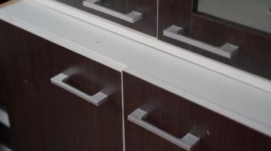 Eski ikinci el mobilyalar bir ağacın altında. Ahşap efektli filmlerle kaplı bir karton dolap. Modern komodinin kirli hali. Yüksek kaliteli FullHD görüntüler