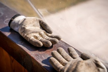 Pis bahçıvanın eldivenlerini yakından çek. İşten sonra topraktaki bir çiftçinin lastik beyaz eldivenleri.