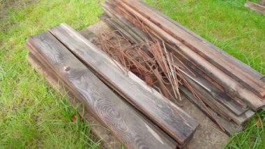 Sokaktaki metal ve ahşap tahtaları yeşil çimlerin arka planına, pürüzsüz kamera hareketlerine karşı. Yüksek kaliteli FullHD görüntüler