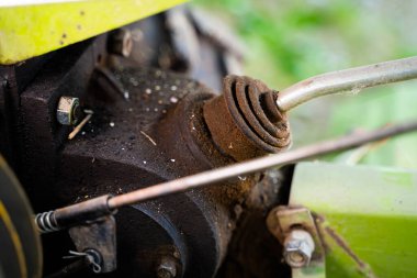 Bulanık bir arkaplanda traktörün arkasındaki vites kolu. Tarım makinelerinin kontrol unsurları. Rototiller bağlantısı ve vites değiştirme