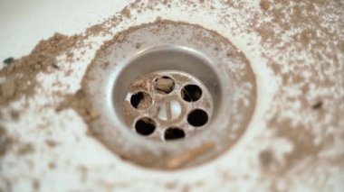 Kumda beyaz bir lavabo var, yakın plan. Kirli beyaz seramik lavabo. Yüksek kaliteli FullHD görüntüler
