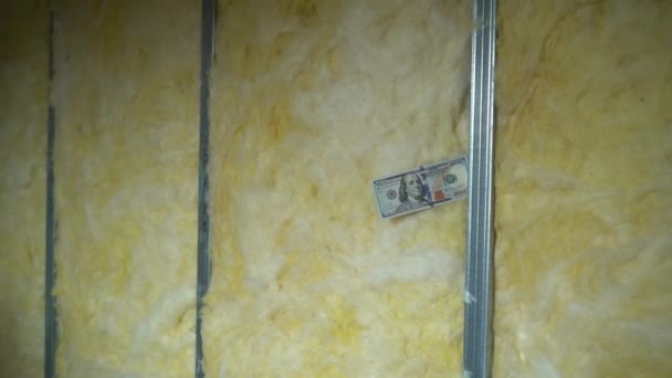 ガラスウールでフレームの壁にお金 金属Uプロファイルに固定された100ドルと建設現場で黄色のガラスウール 高品質のフルHd映像 — ストック動画