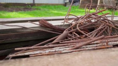 Paslı hurda metal ve eski ahşap tahtalar yeşil çimlerin arka planına yakın plan. Yüksek kaliteli FullHD görüntüler