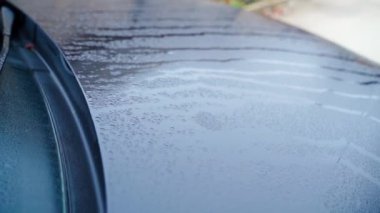 Sabah su damlalarındaki siyah araba, yakın plan, düzgün kamera hareketi. Sonbahar yağmurlu sabahı. Yüksek kaliteli FullHD görüntüler