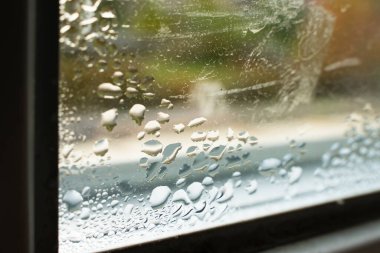 Drops of condensation on the window close-up. Humidity and temperature difference between the street and the room clipart