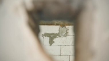 Kamera havalandırılmış beton tuğlalardan oluşan duvardaki bir delikten uçuyor. Havalandırılmış beton bloktan havalanan beton bir duvarın tahrip edilmesi. Yüksek kaliteli FullHD görüntüler