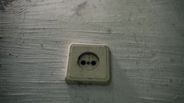 Kirli, düz olmayan bir duvarda eski bir elektrik prizi. Yakın çekim, düzgün kamera hareketi. Yüksek kaliteli FullHD görüntüler