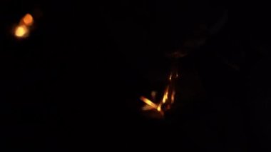 Bir balta, karanlıkta bir öğütücünün aşındırıcı tekerleğinde keskinleştirilir ve kıvılcımlar yakın plan çekilir. Karanlıkta parlak sarı kıvılcımlar. Yüksek kalite 4k görüntü