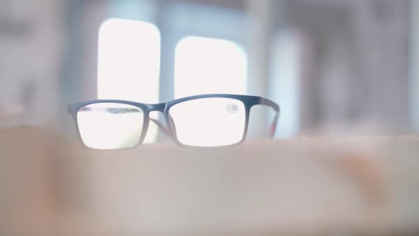 Black Frame Glasses Large Convex Lenses Close Wooden Boards Blurred — Stock Video