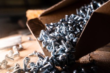 Metal profil için kendi kendine dokunan parlak vidalar kutudan yere yakın çekimde parçalandı.