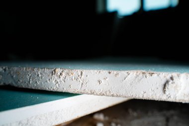 Alçıpanın kesildiği yer. Nemlenmeye dayanıklı bir alçıpan kapağı. Alçı taşı doldurucu yapı malzemesi