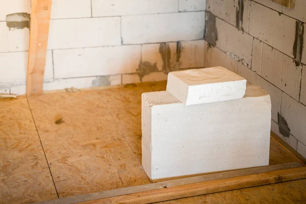 Aerated concrete block builds on oriented strand board at a construction site. Thick polystyrene foam on a gas block