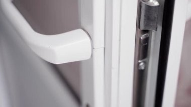 Plastik kapı kolunun yanında çatlak bir ceset var. Yakın plan. Kapının kırılma izleri, düzgün kamera hareketleri. Yüksek kaliteli FullHD görüntüler