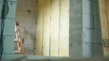İnşaat sırasında boş duvarları, havalandırmalı beton tuğlalardan duvarları olan bir ev. Duvarda cam yün var. Yüksek kaliteli FullHD görüntüler
