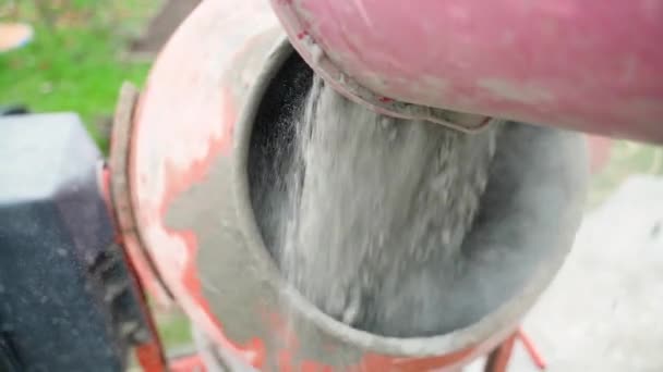 Egy Vödör Száraz Cementport Öntenek Egy Működő Betonkeverőbe Lassított Felvételben — Stock videók