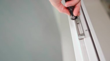 Beyaz plastik bir kapının metal parçalarını sökmek, yakın plan. Alt manzara. Yüksek kalite 4k görüntü