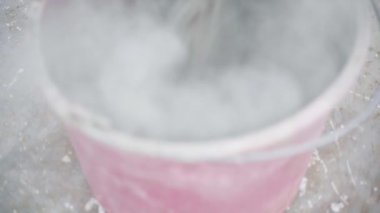 Kurutulmuş çimento plastik kovaya dökülüyor, yakın plan. Yüksek kaliteli FullHD görüntüler