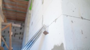 Havalı beton tuğlalar ve metal U profili duvarı, bir inşaat alanında yakın plan. Yüksek kaliteli FullHD görüntüler