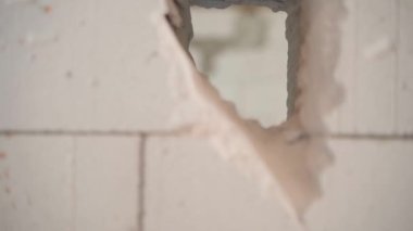 Havalandırmalı beton tuğlalardan oluşan duvardaki bir delikten geçen odanın geçişi. Gaz bloğu evinin duvarındaki delikten, düzgün kamera hareketinden. Yüksek kaliteli FullHD görüntüler