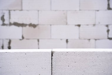 Havalı beton tuğlalardan oluşan bir duvarın arka plan kağıdı. Havalandırılmış beton blok önplanı ve bulanık arkaplan