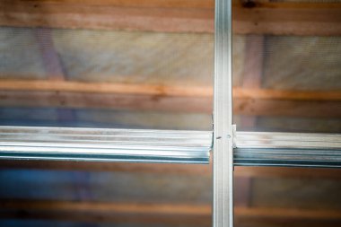 Frame from a metal profile for drywall close-up on a blurred background. Connection of parts from a metal profile in an interior partition