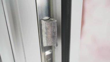 Plastik kapının kilidinin diline yakın çekim. Plastik kapıların metal parçalarının direncini kırın. Yüksek kalite 4k görüntü