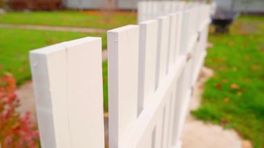 Kırsal bir çimenlikte beyaz tahta bir çit. Sonbahar akşamı. Yüksek kaliteli FullHD görüntüler