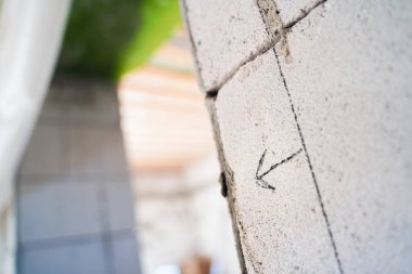 Duvardaki bir ok bulanık arka plandaki bir geçidi işaret ediyor. Özel bir evde duvarların yeniden yapılandırılması.