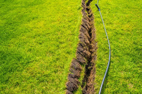 在已完成的草坪上自行安装带有可伸缩洒水器的灌溉系统 在草坪下铺有喷雾器的水管作灌溉之用 图库照片