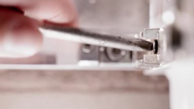 Kıvırcık bir tornavidanın yakın çekimi vidaları kendi kendine söker. Plastik bir kapının metal bir parçasını sökmek. Yüksek kalite 4k görüntü