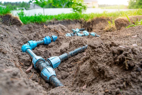 Plastik borular ve çim sulama için elektrik tesisatı. Bahçedeki suyu kesmek için bağlantı tesisatları ve vanalar