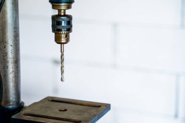 Bulanık ışık arkaplanına yakın metal matkapla delme makinesi